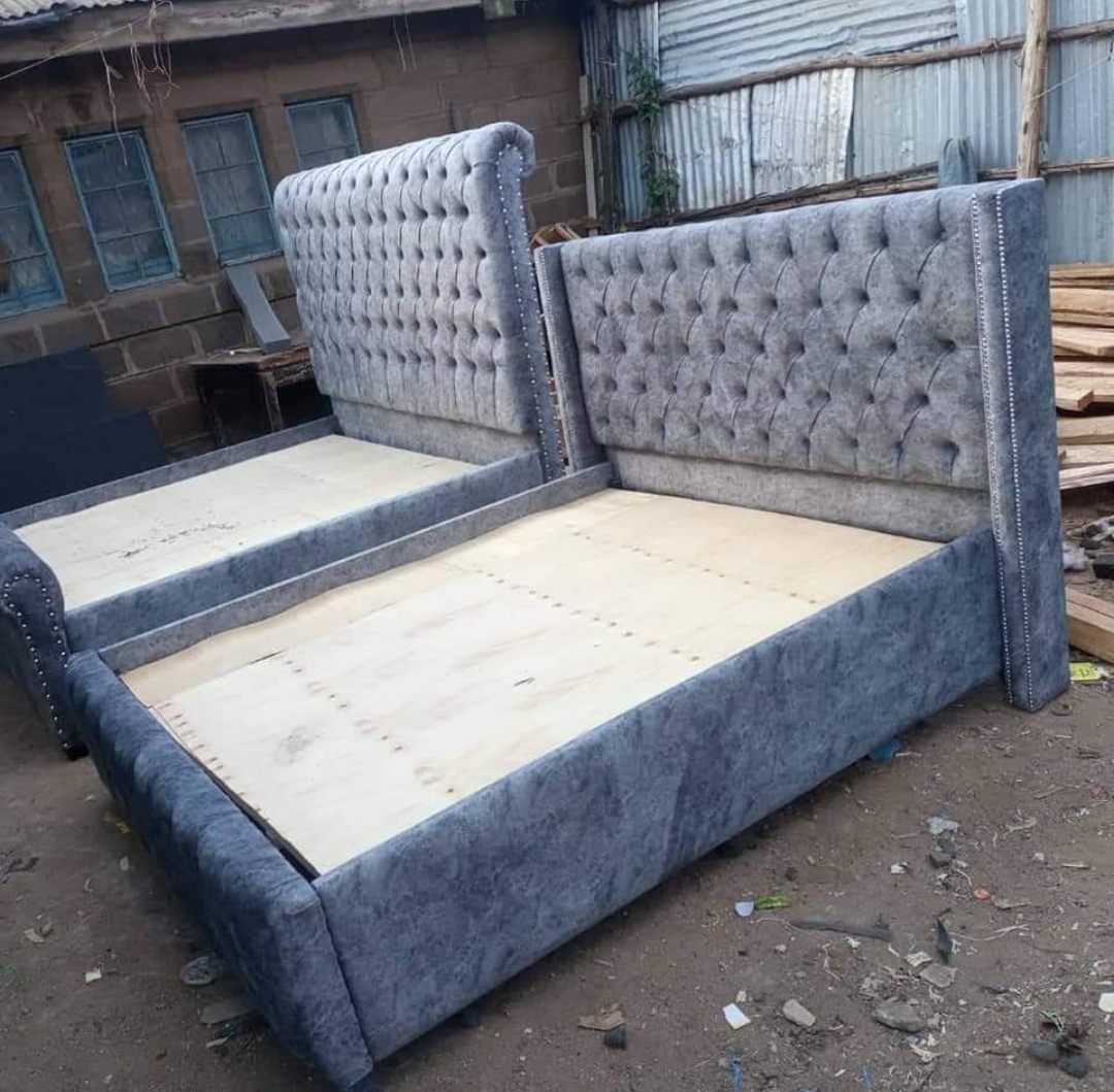 Grey velvet Chesterfield bed with a deep buttoned, studded headboard