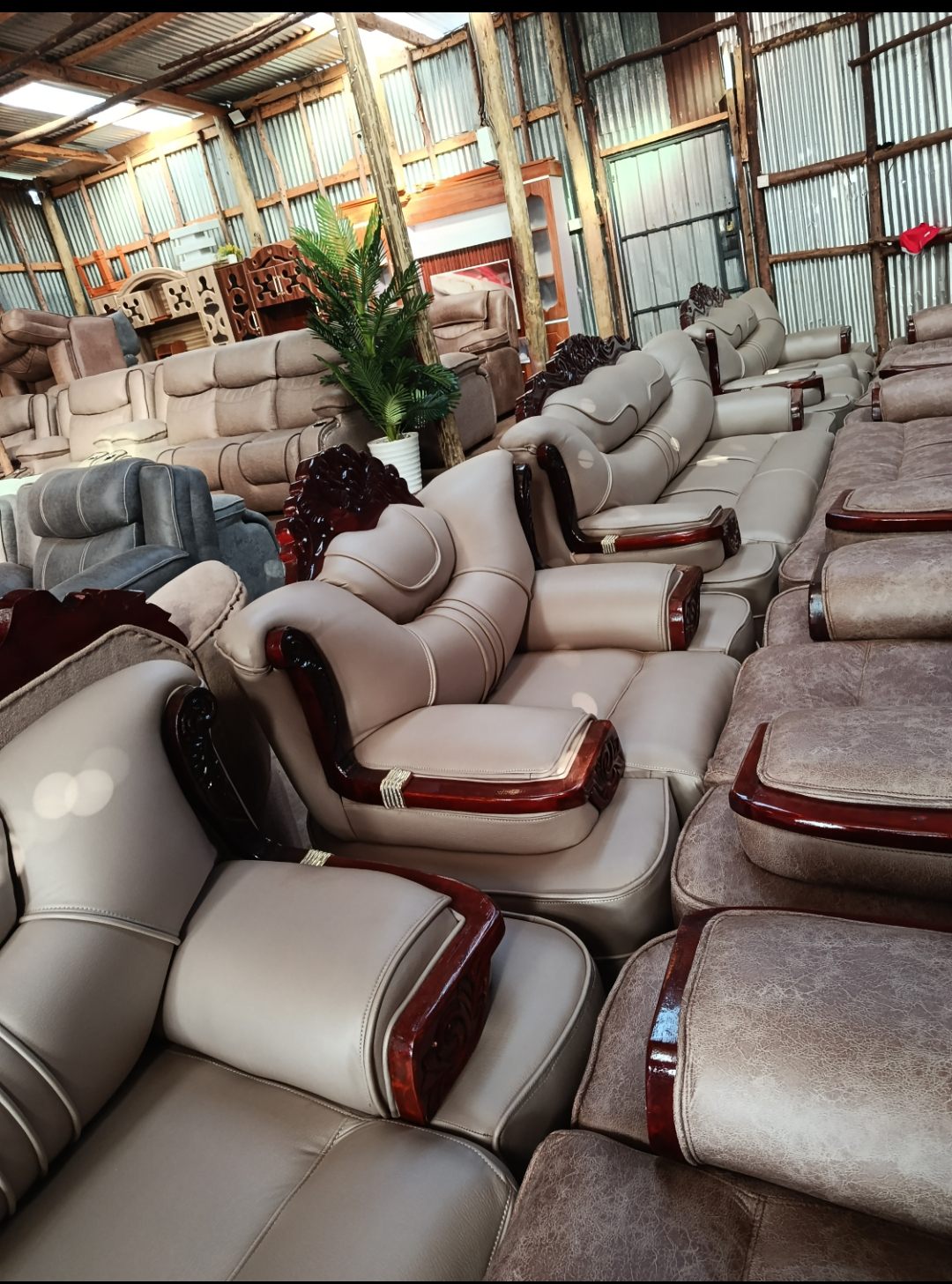 Rows of leather and fabric sofa sets on display inside the Homewood showroom