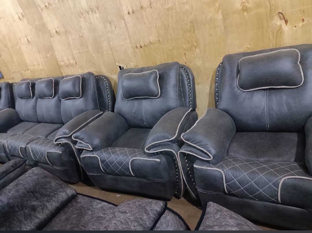 Grey studded suede armchairs with diamond-stitched seats